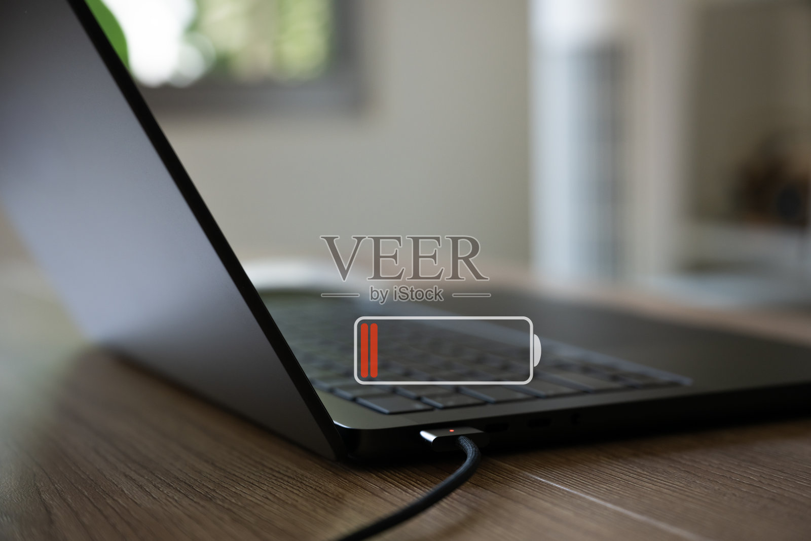 带有充电接口和电池耗尽图标的笔记本电脑照片摄影图片