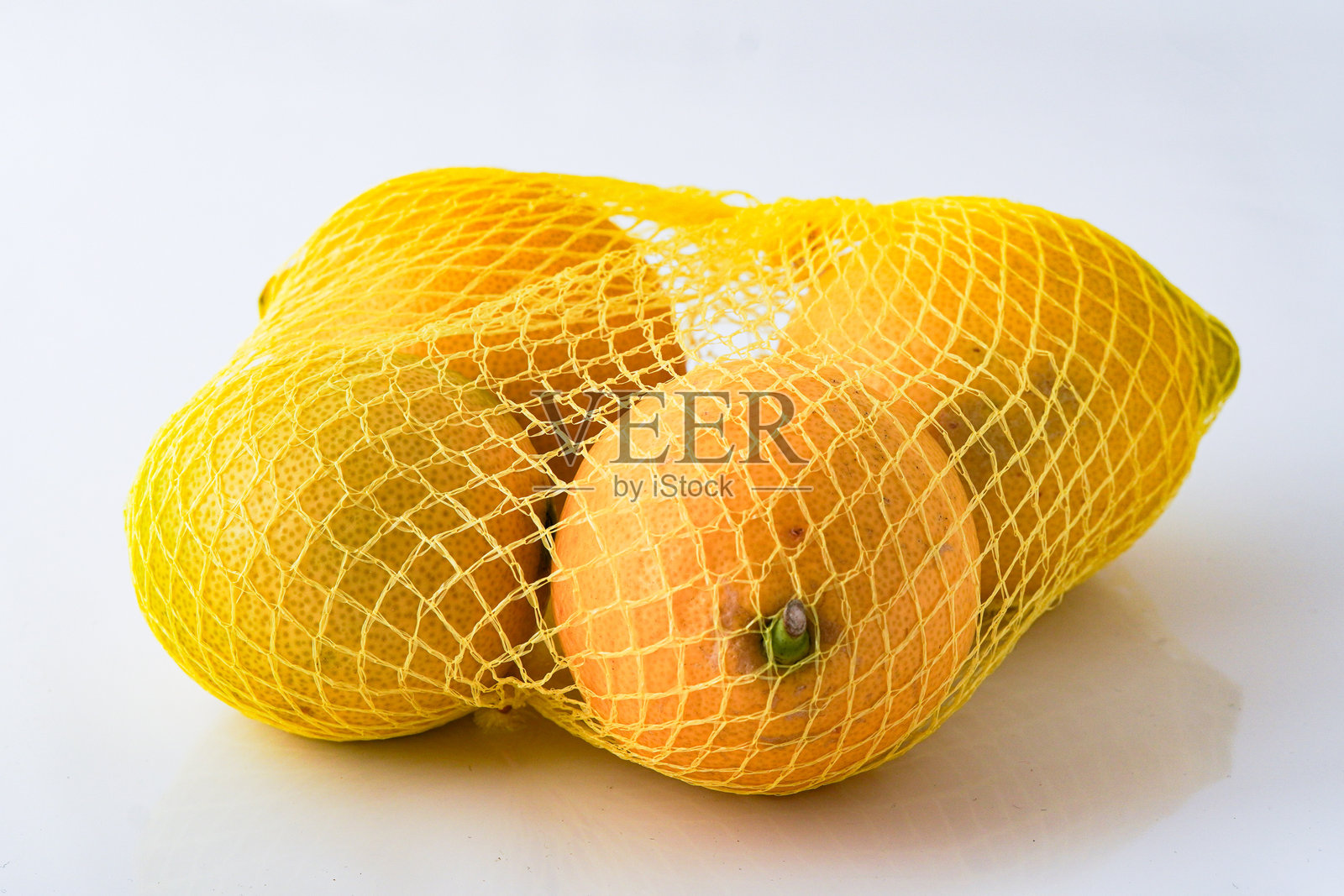 新鲜柠檬用网袋包装，准备出售照片摄影图片