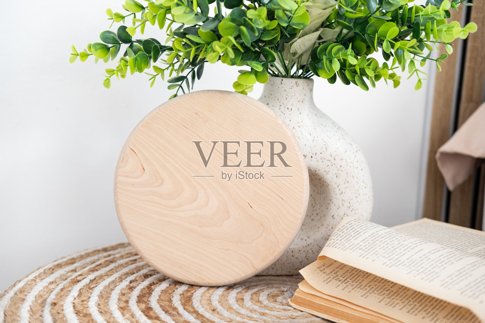 装饰性木质杯垫，上面放着绿色植物和一本复古书籍，摆放在桌子上照片摄影图片