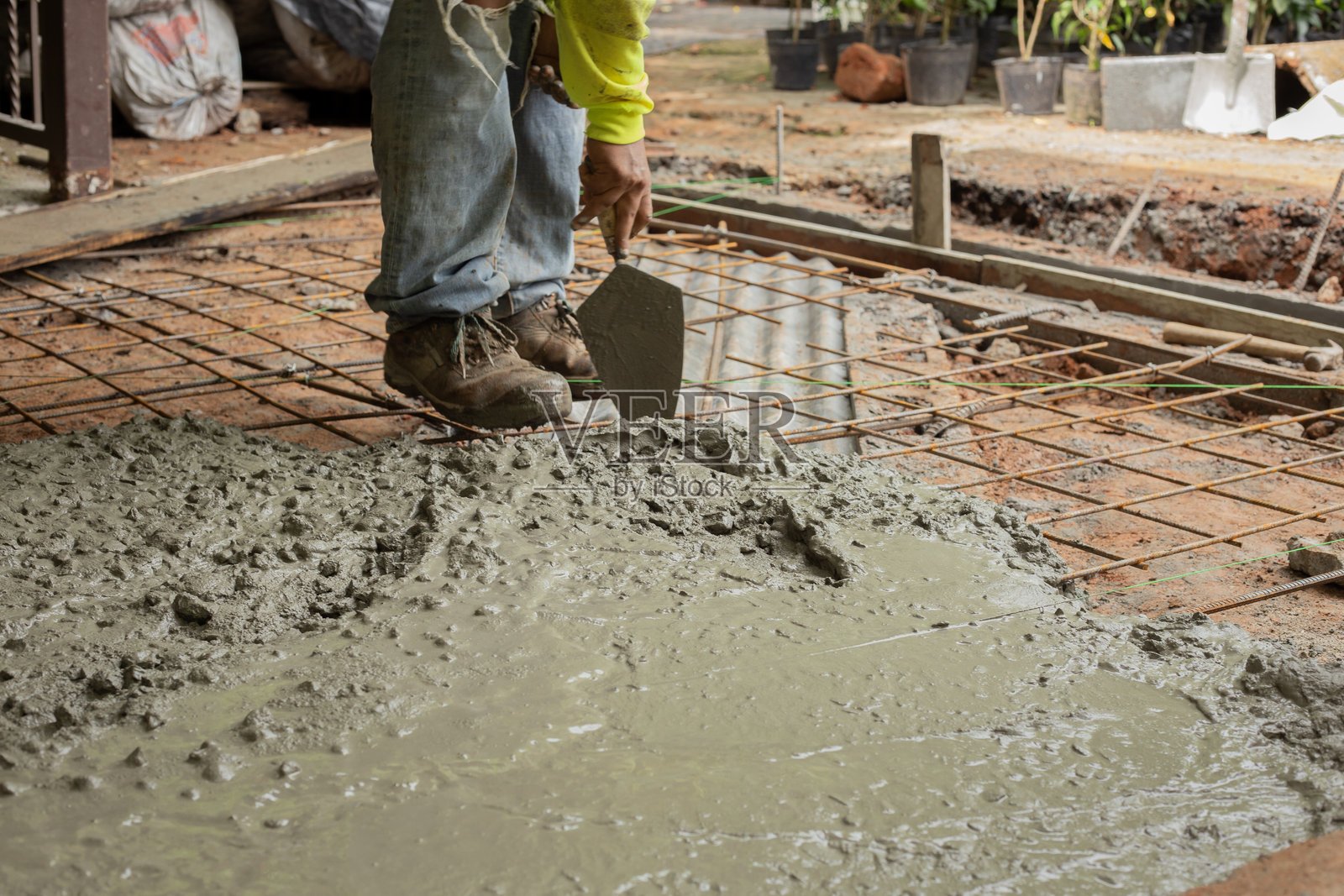 工人在建筑工地上将湿混凝土倒在金属加固上照片摄影图片