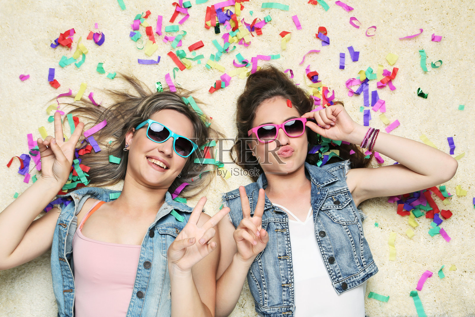 两位年轻女性躺在地毯上的肖像照片摄影图片