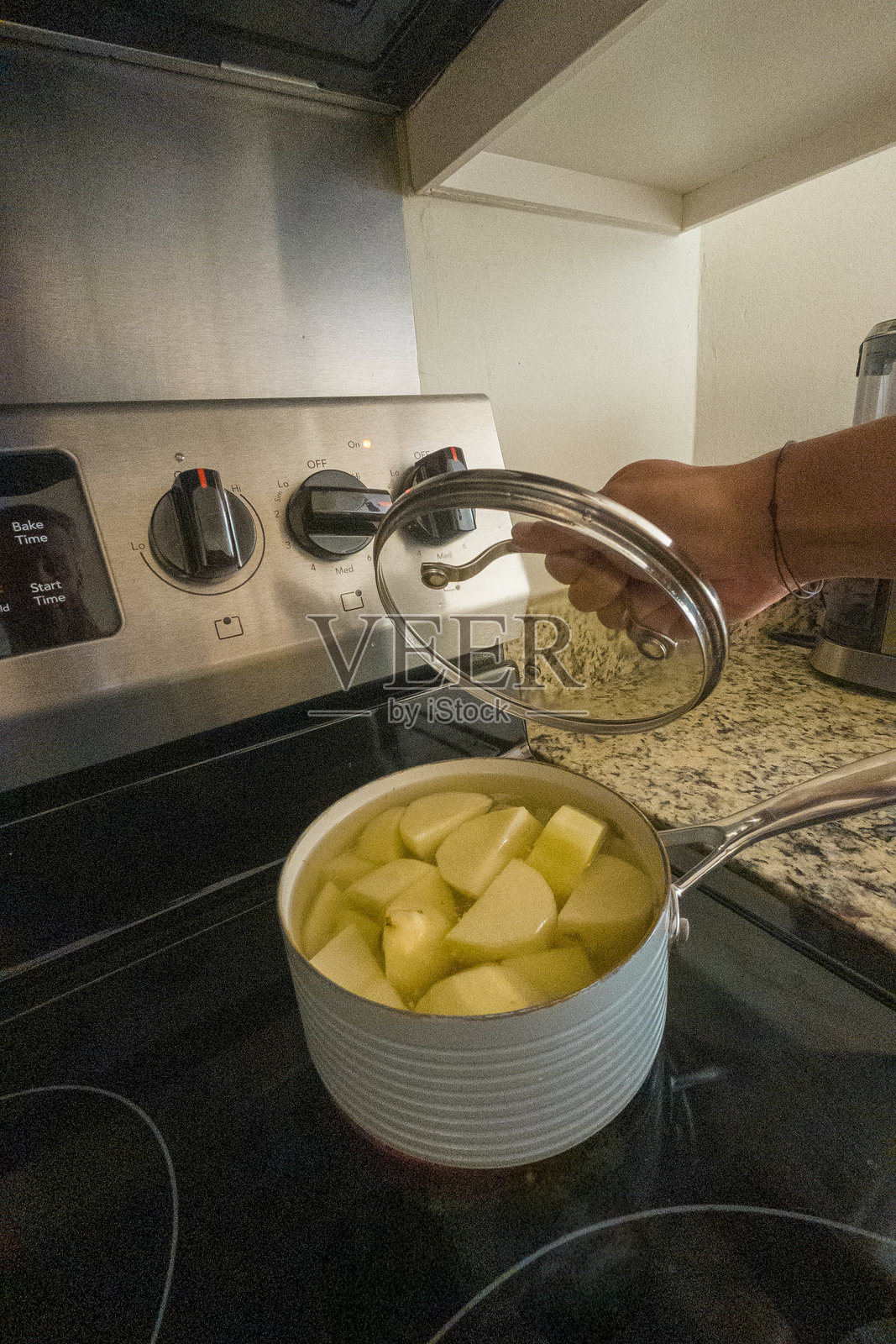 一个人在炉子上的锅里煮土豆照片摄影图片