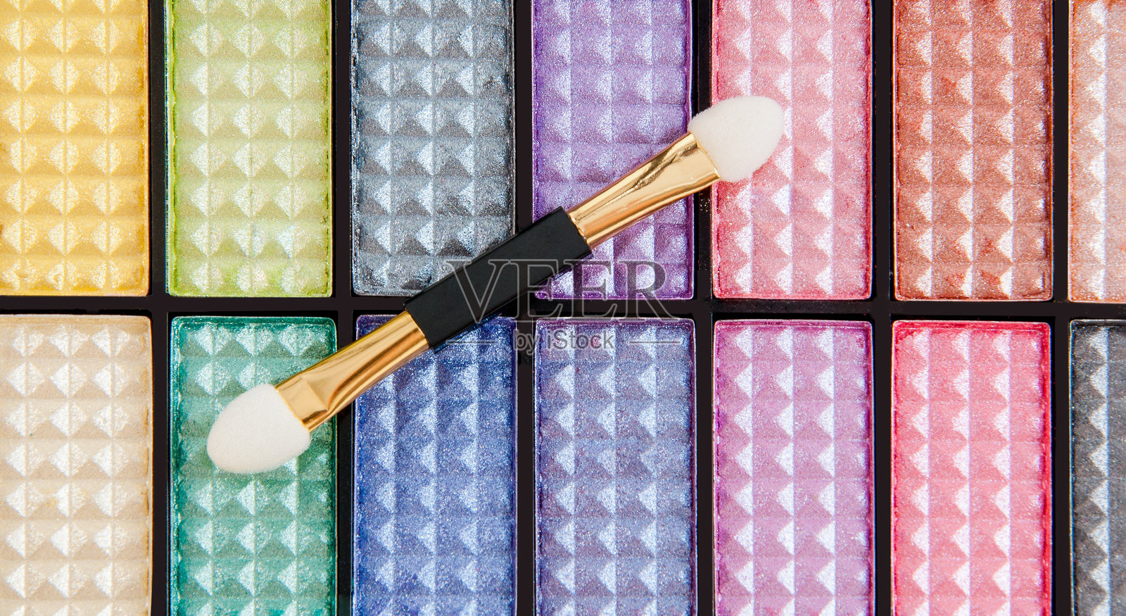 一款色彩丰富的眼影盘，配有鲜艳的色调和一个涂抹刷。照片摄影图片