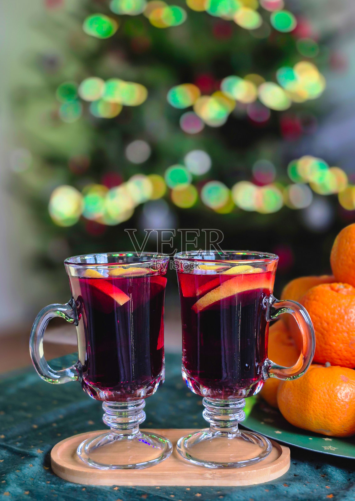 热红酒在玻璃杯中，背景是水果和圣诞树照片摄影图片