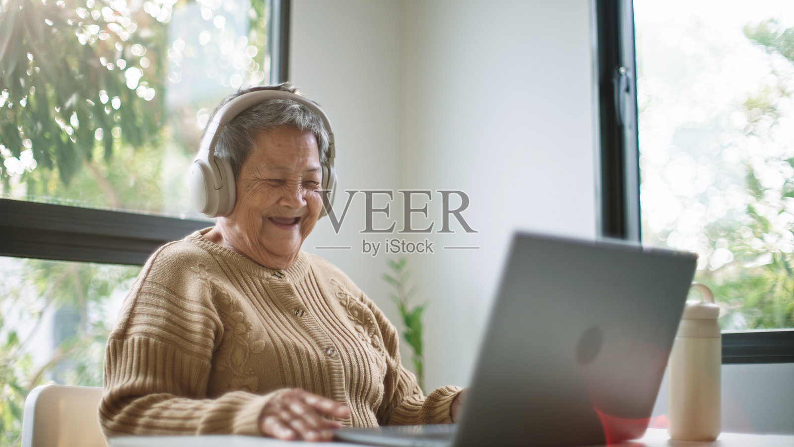 快乐的老年人正在用笔记本电脑观看电影。照片摄影图片