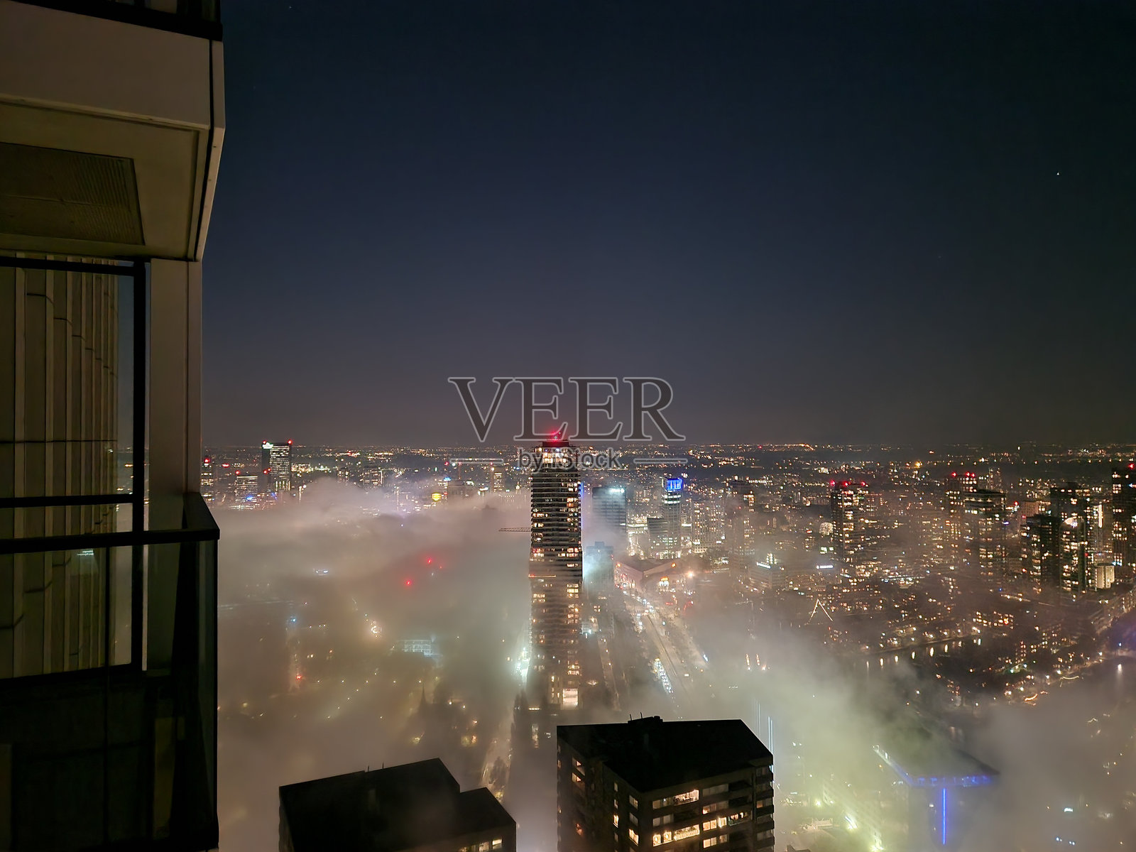 黄昏时分，鹿特丹的天际线被浓雾笼罩，桥梁和摩天大楼若隐若现。照片摄影图片