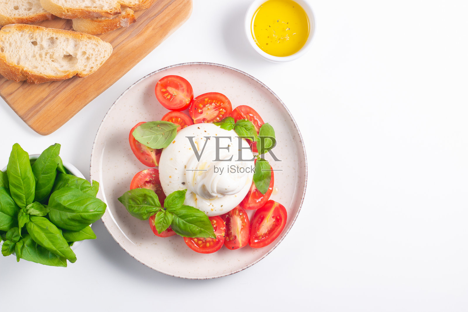 美味的意大利卡普雷塞沙拉，配有切片马苏里拉奶酪、西红柿、罗勒，背景是面包。照片摄影图片