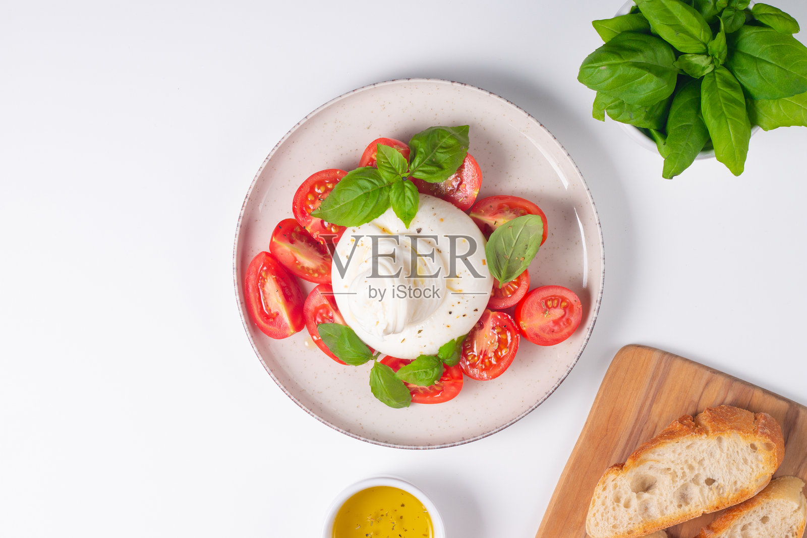 美味的意大利卡普雷塞沙拉，配有切片马苏里拉奶酪、西红柿、罗勒，背景是面包。照片摄影图片