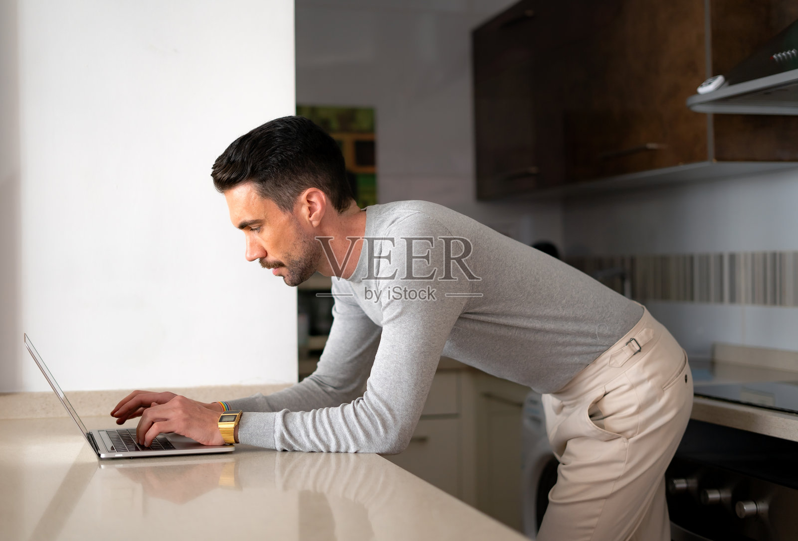 年轻男孩在厨房使用笔记本电脑照片摄影图片