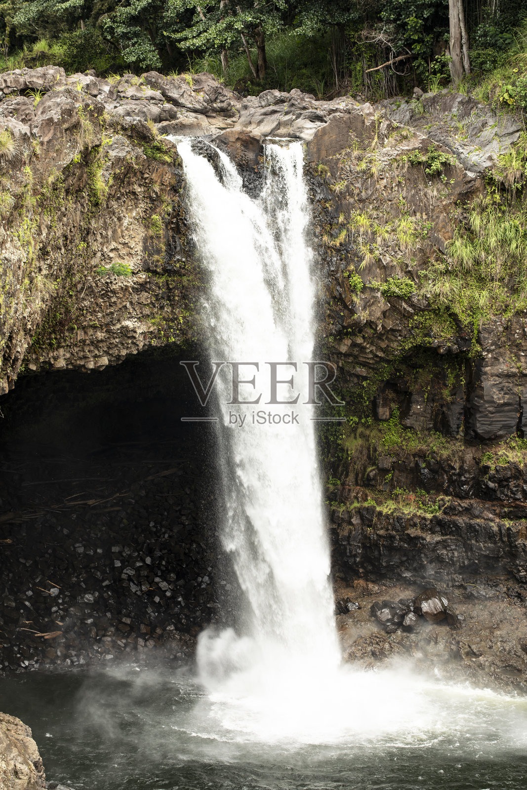 宏伟的彩虹瀑布，夏威夷 热带森林中岩石悬崖上的瀑布倾泻而下照片摄影图片