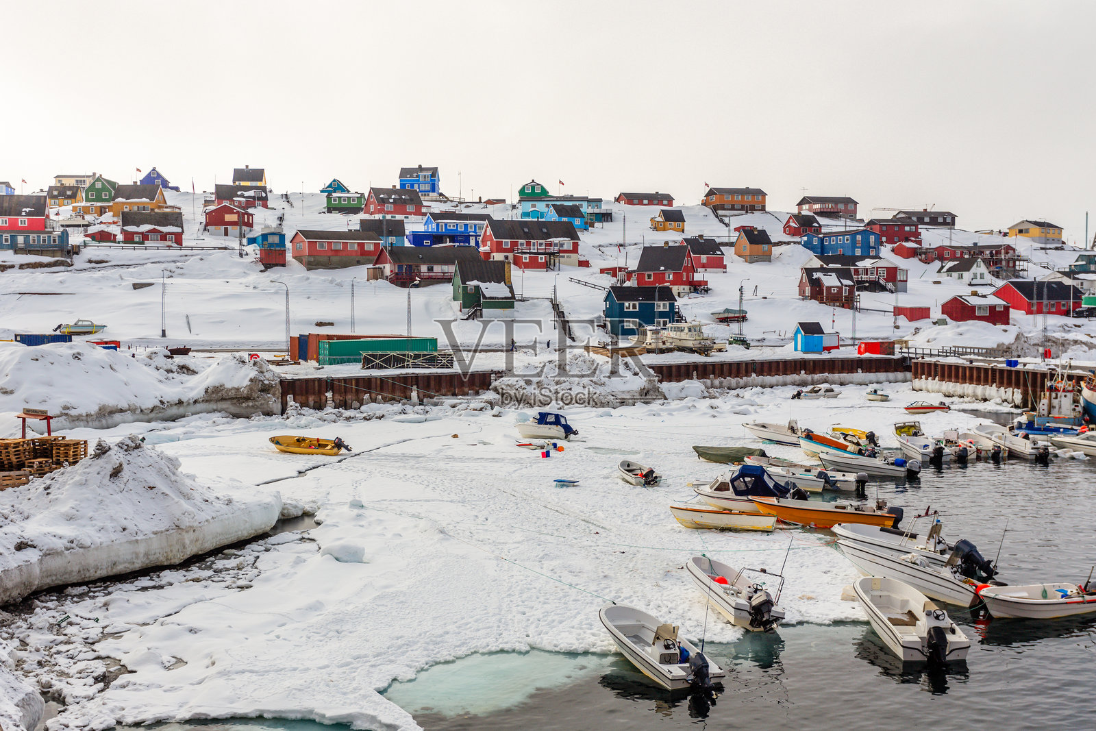 格林兰阿西阿特市的港口区域，背景是摩托艇和色彩斑斓的因纽特房屋。照片摄影图片