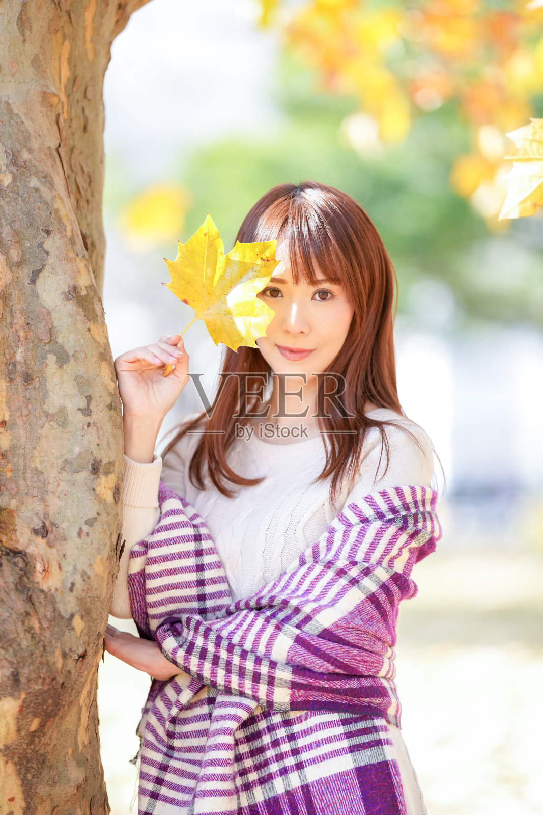 一位三十多岁、长发的女性站在美丽的秋叶中照片摄影图片