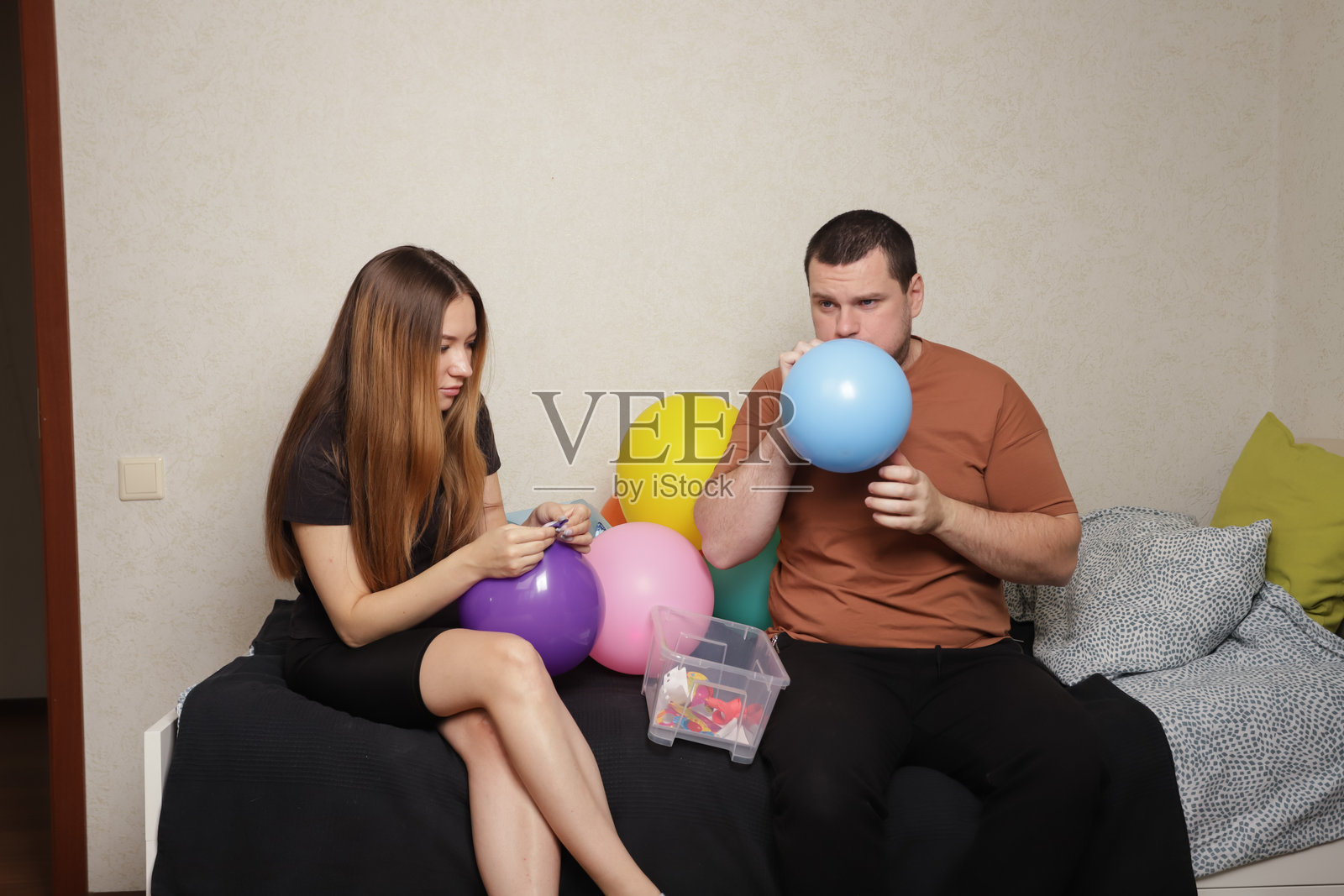 父亲和女儿为派对装饰吹气球，准备室内节日庆祝，家庭装饰的快乐时刻。照片摄影图片