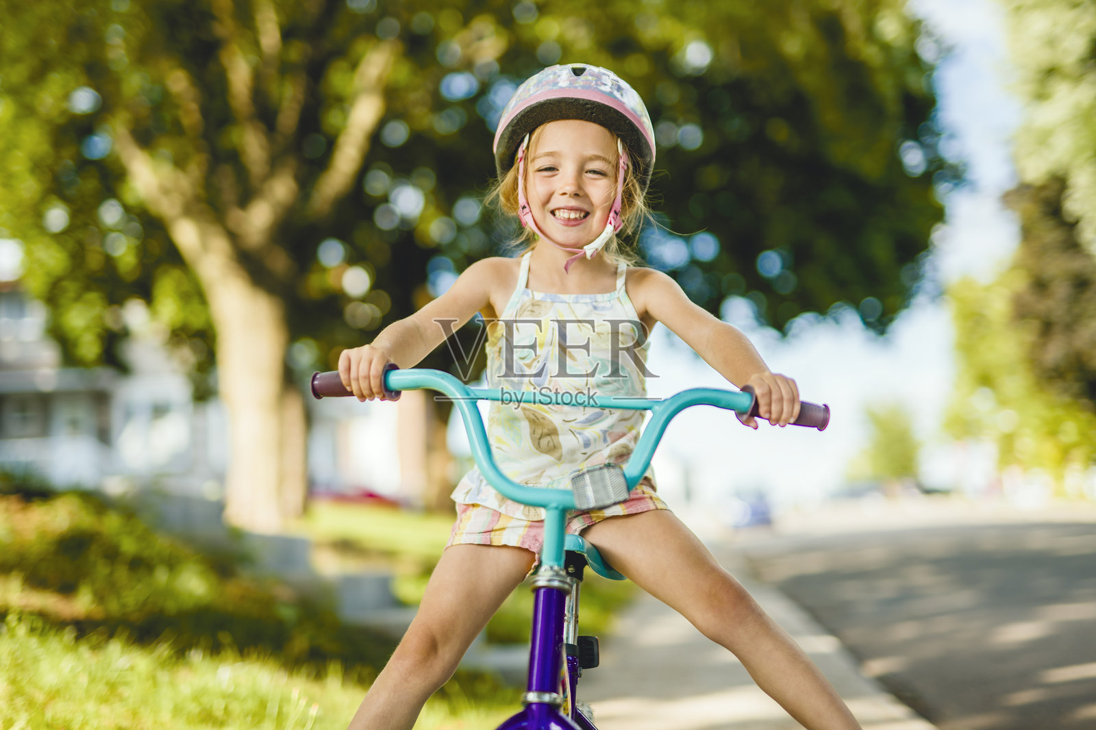 4岁女孩骑自行车时玩得很开心照片摄影图片