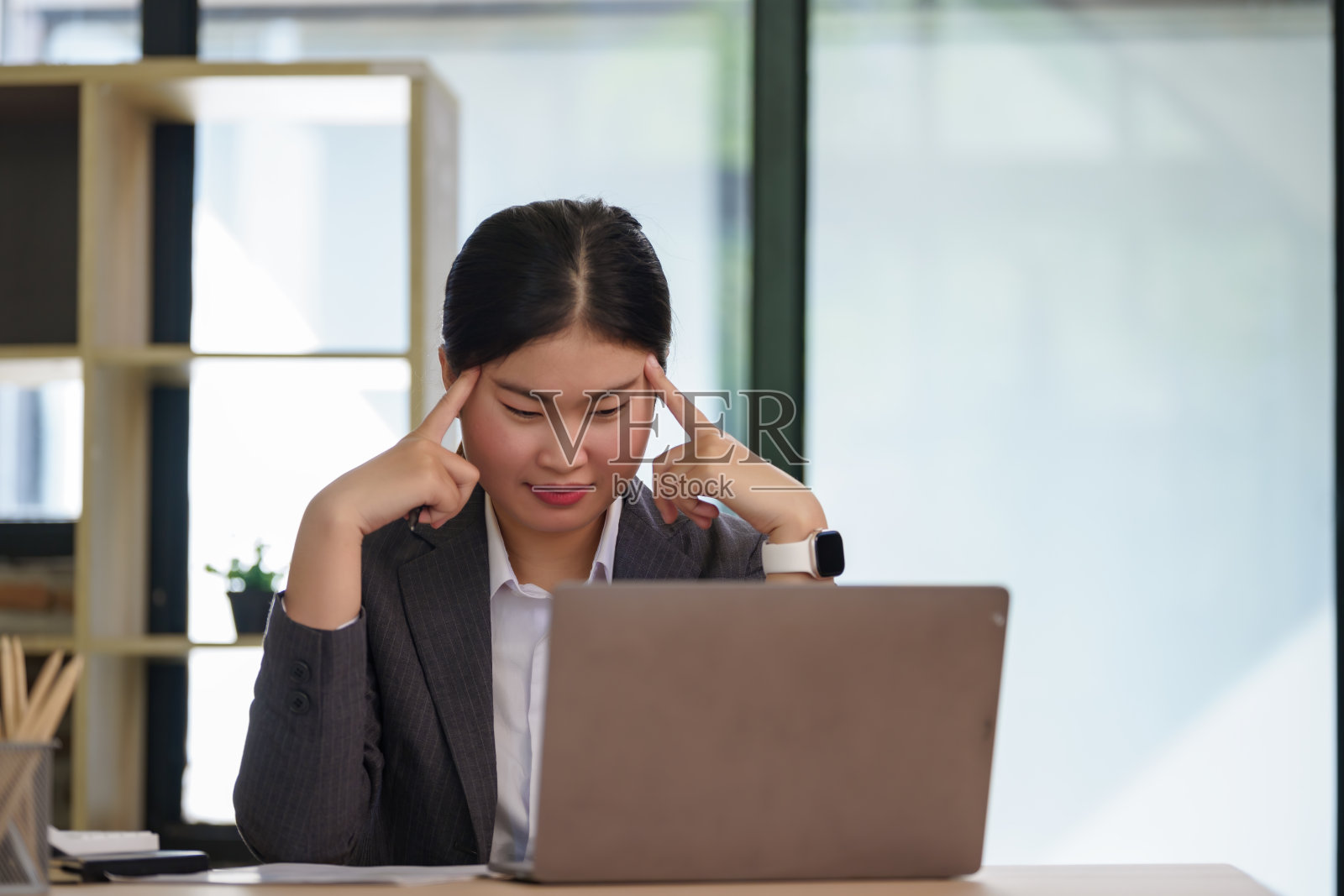 美丽的亚洲女商人在办公室使用笔记本电脑工作，感到沮丧。照片摄影图片