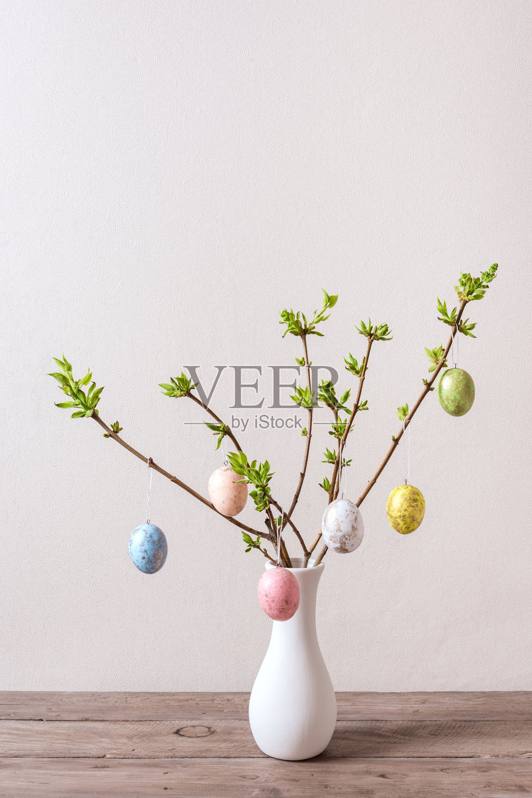 装满五彩复活节彩蛋的花瓶挂在春天的树枝上照片摄影图片