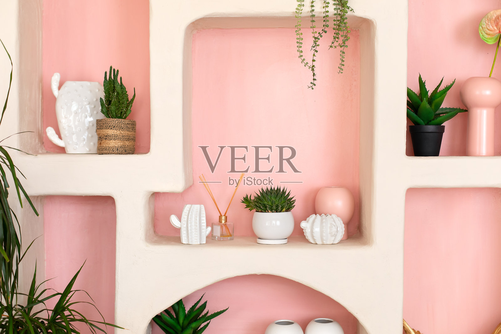 现代家居装饰。架子上摆放着一组盆栽仙人掌。时尚的“侘寂”风格客厅，设计感十足的架子上有家居装饰品、香薰扩散器、花瓶和盆栽植物。模板。照片摄影图片