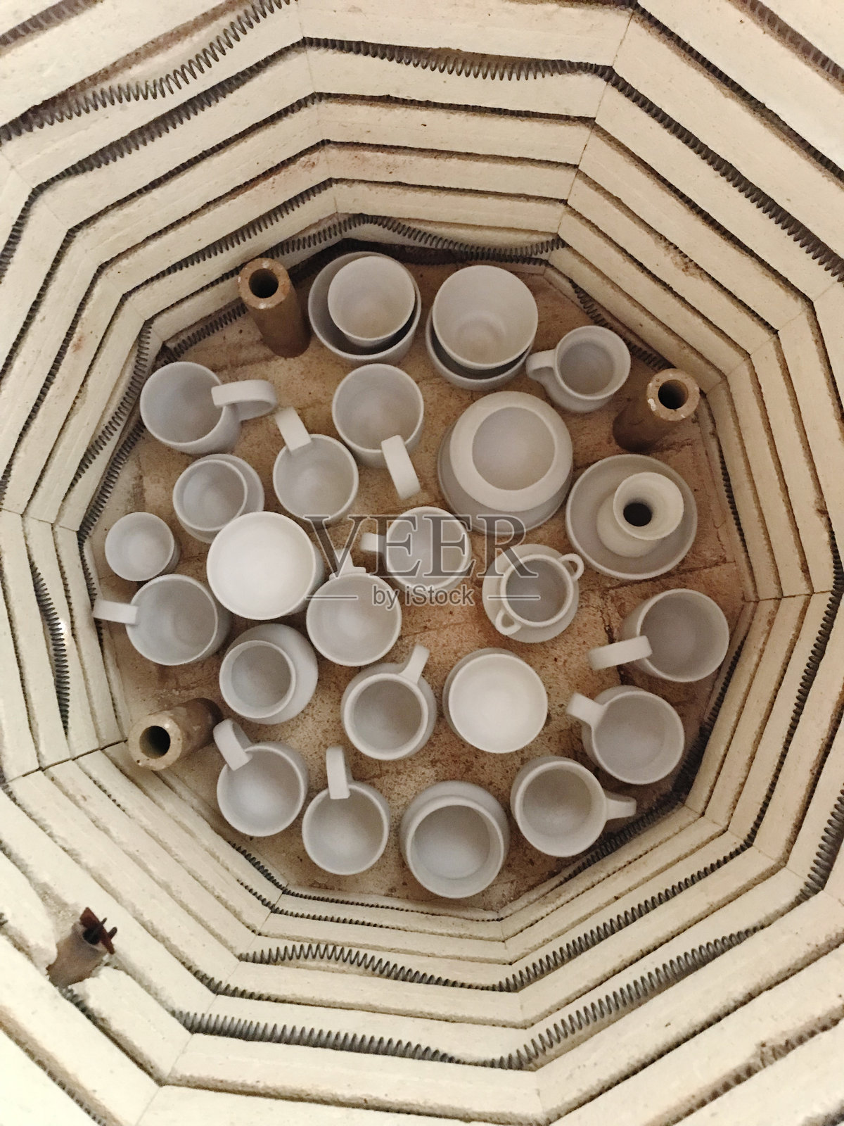 许多自制陶土杯在陶炉底部照片摄影图片