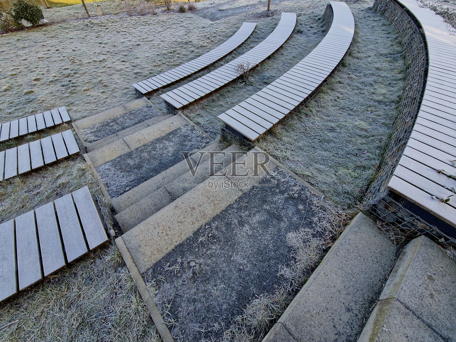 石头长椅在木板装饰的拱门内。户外剧院圆形剧场。夏季电影院礼堂。公园公共空间的俯视图，适合剧院和野餐。照片摄影图片