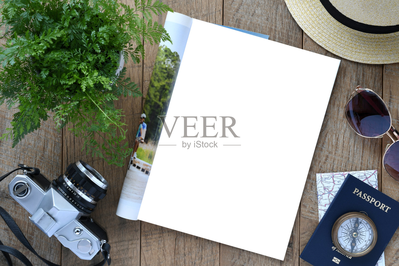 一本打开的杂志放在桌子上，留有一页白色空白页以供展示。照片摄影图片