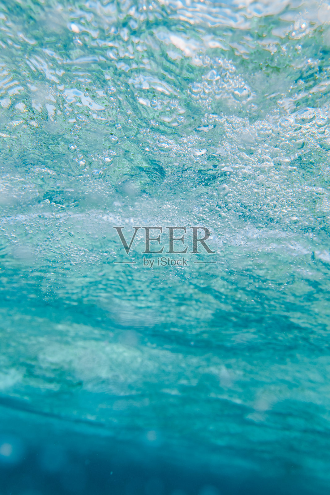 阳光明媚的马尔代夫热带岛屿上的绿松石泻湖，水面波纹和气泡。照片摄影图片