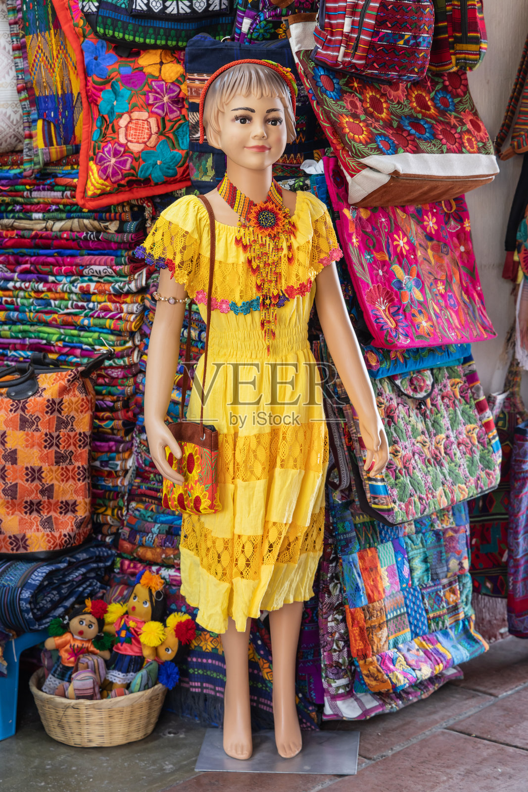 在危地马拉安提瓜的工匠市场上穿着黄色连衣裙的模特。照片摄影图片
