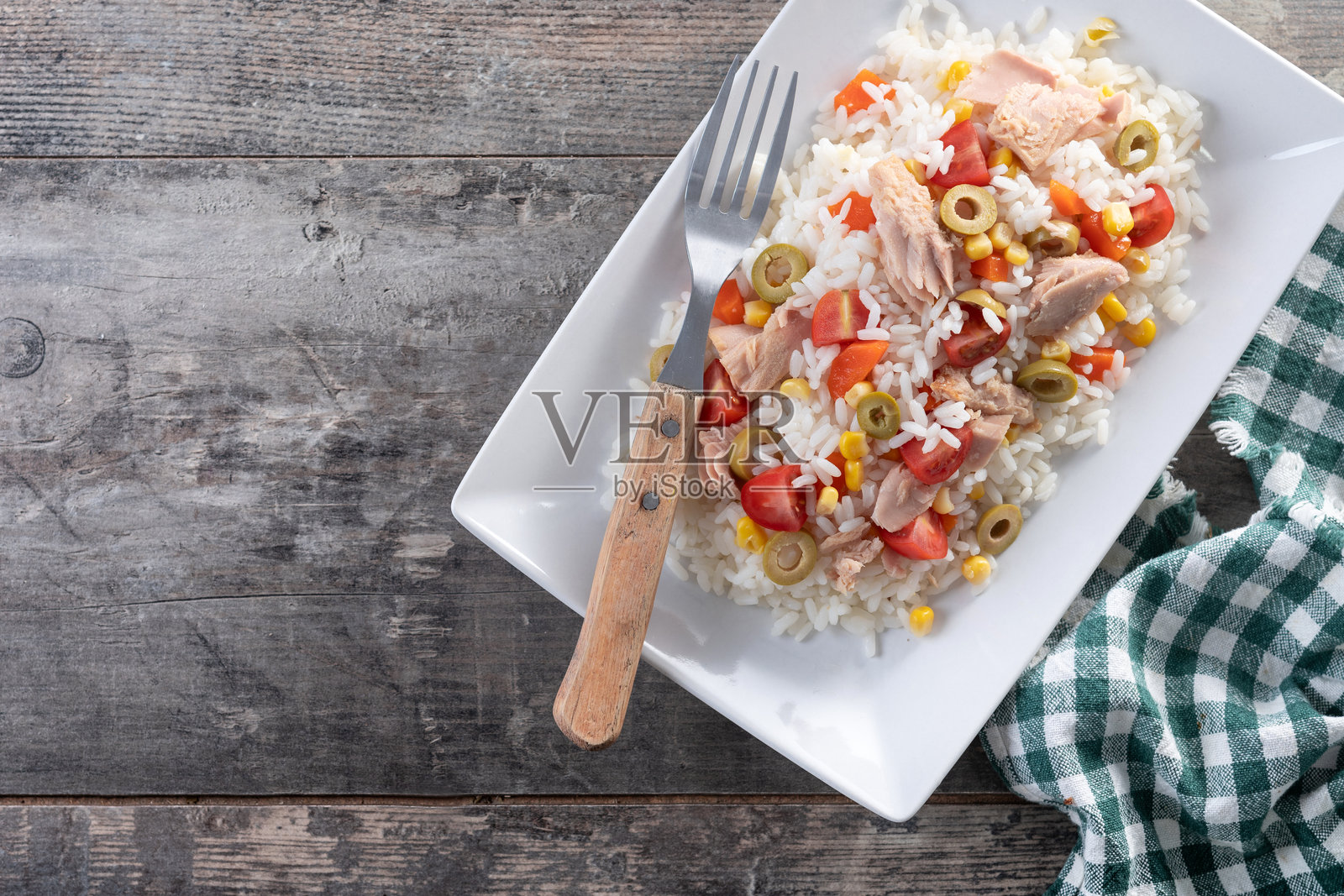 白色背景上的米饭沙拉，配有番茄、玉米、橄榄和金枪鱼照片摄影图片