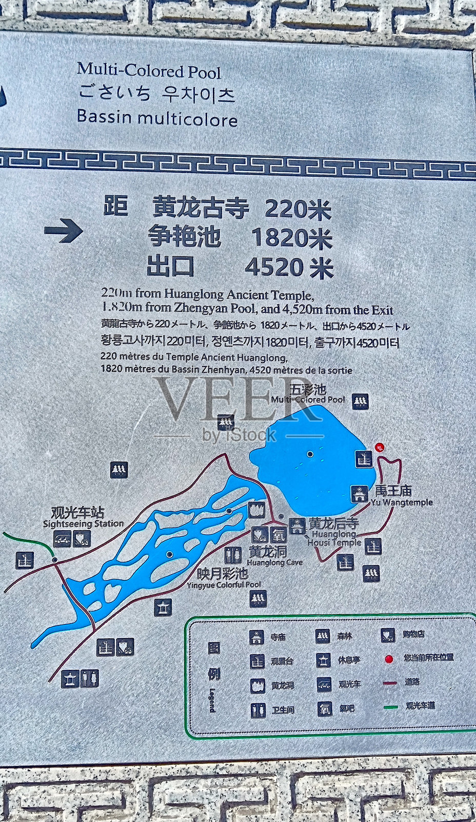 黄龙谷中的标志和信息牌,周围是五彩斑斓的湖泊、白雪皑皑的山峰、绿色森林和冰川。照片摄影图片