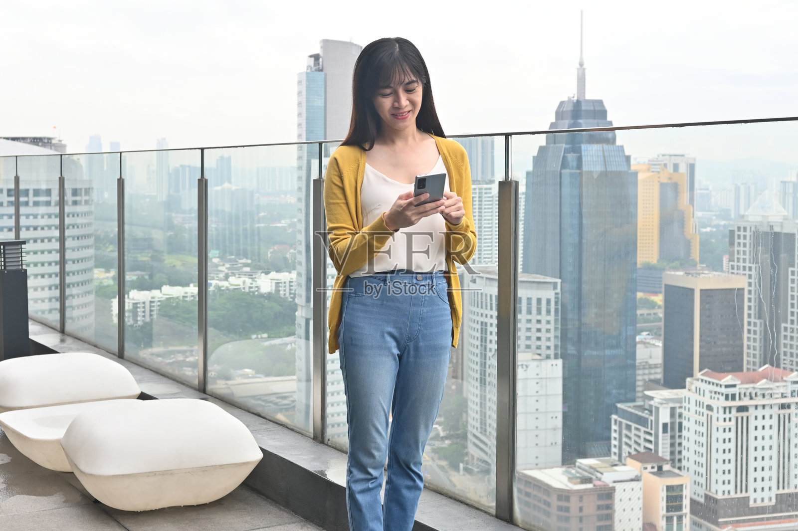 现代时刻：女人在屋顶微笑，俯瞰城市景观照片摄影图片