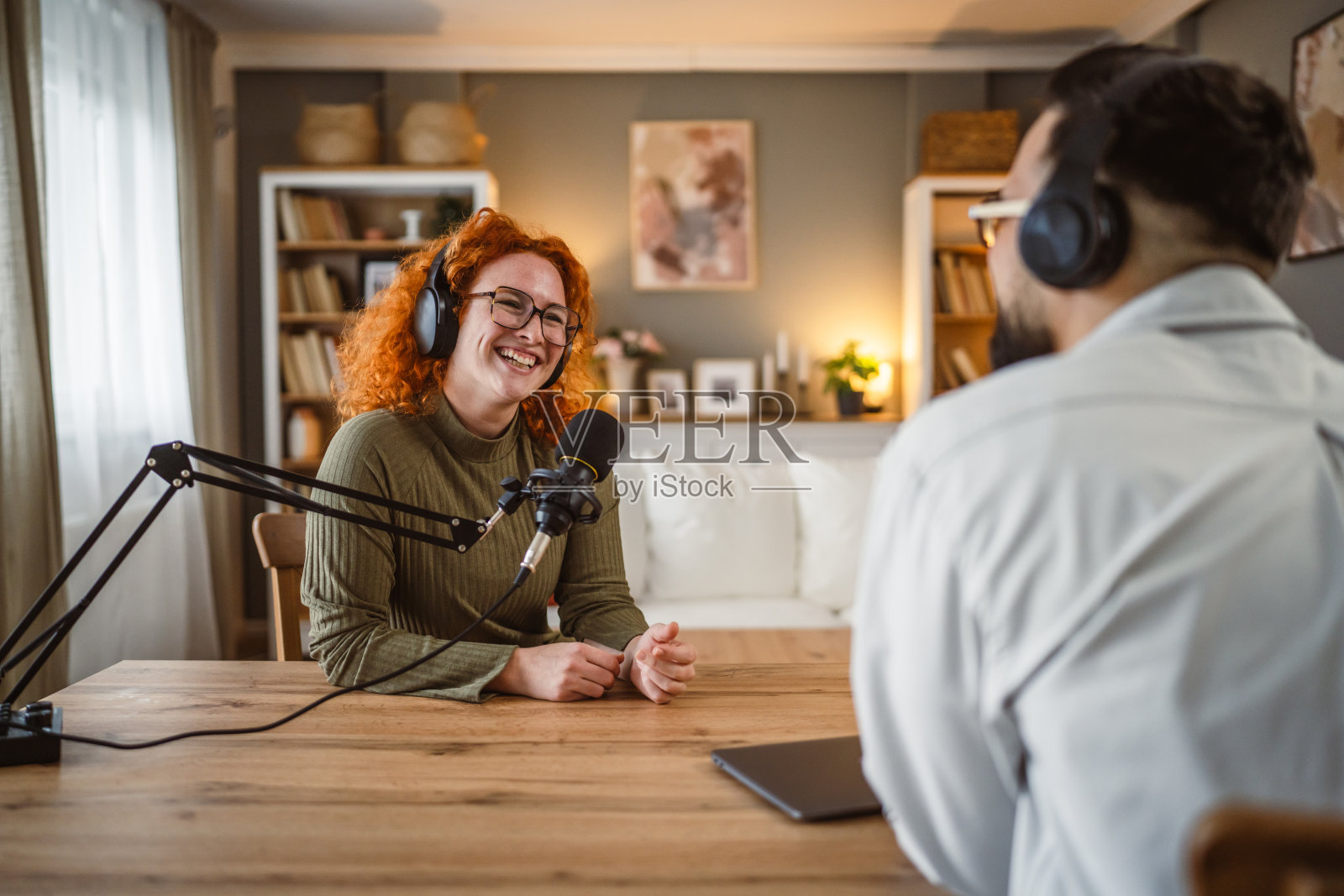 成年女性电台主持人与男性同事一起录制播客时享受乐趣照片摄影图片