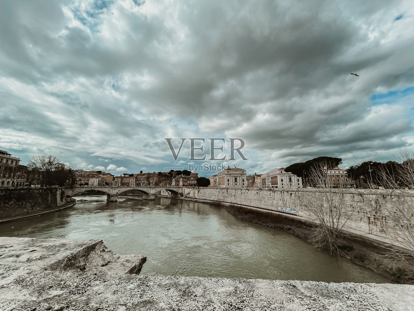 在多云的天空下，台伯河穿过罗马。照片摄影图片