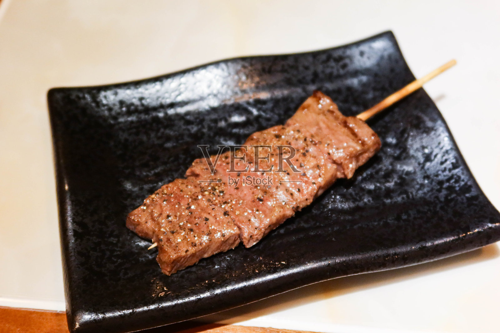 黑盘上的日本烤牛舌串特写照片摄影图片
