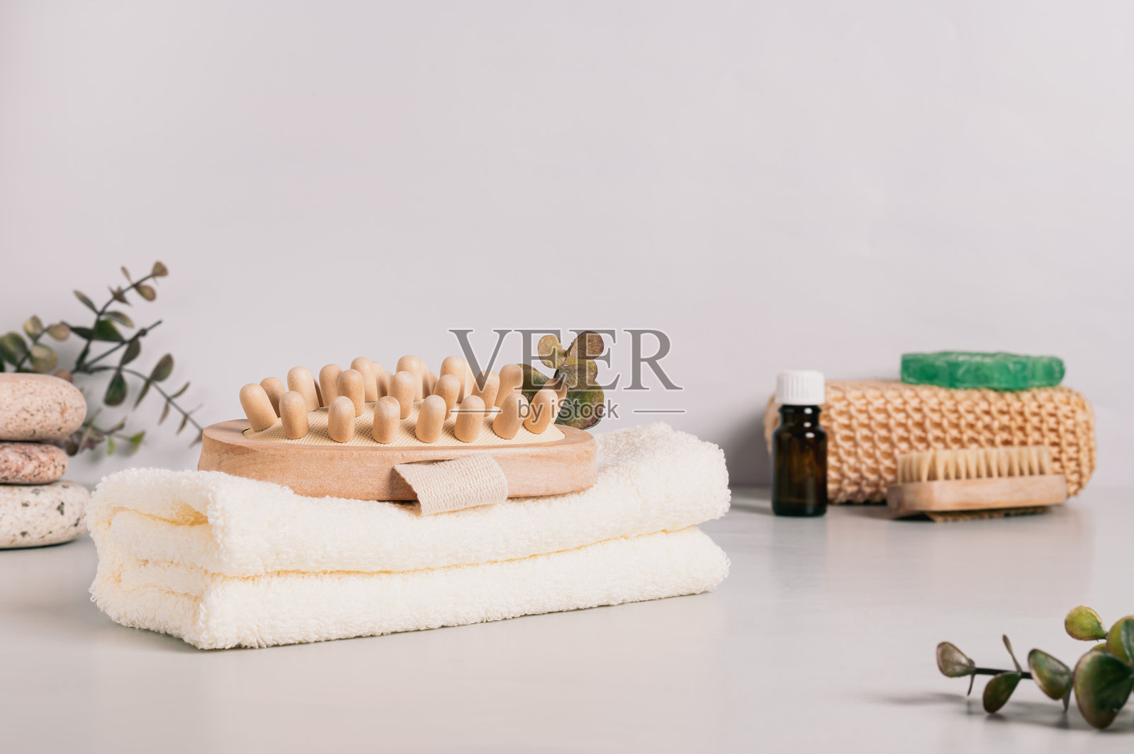 自然有机身体按摩器放在毛巾上，桌子上有水疗用品照片摄影图片