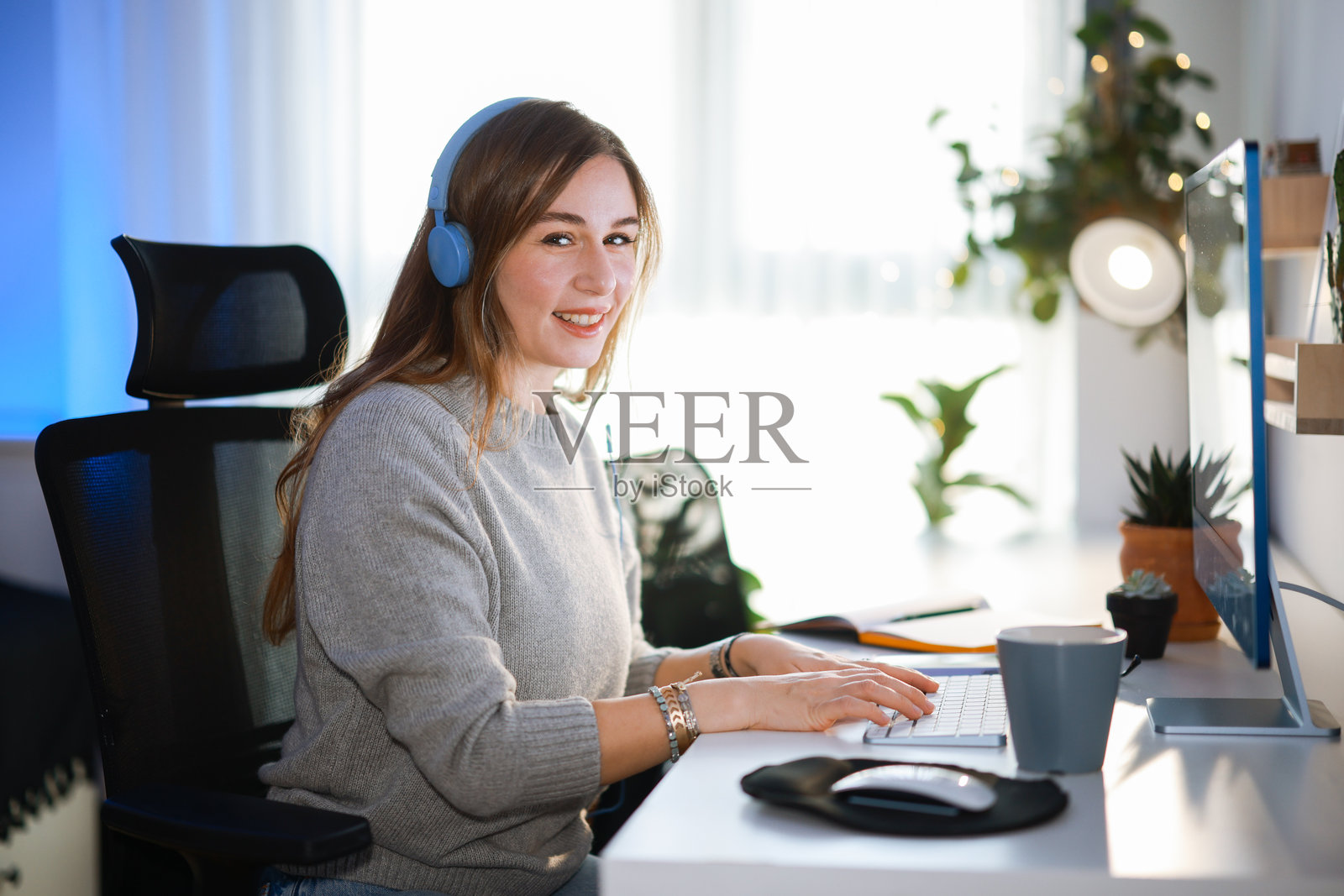 快乐的年轻女性在电脑上工作照片摄影图片