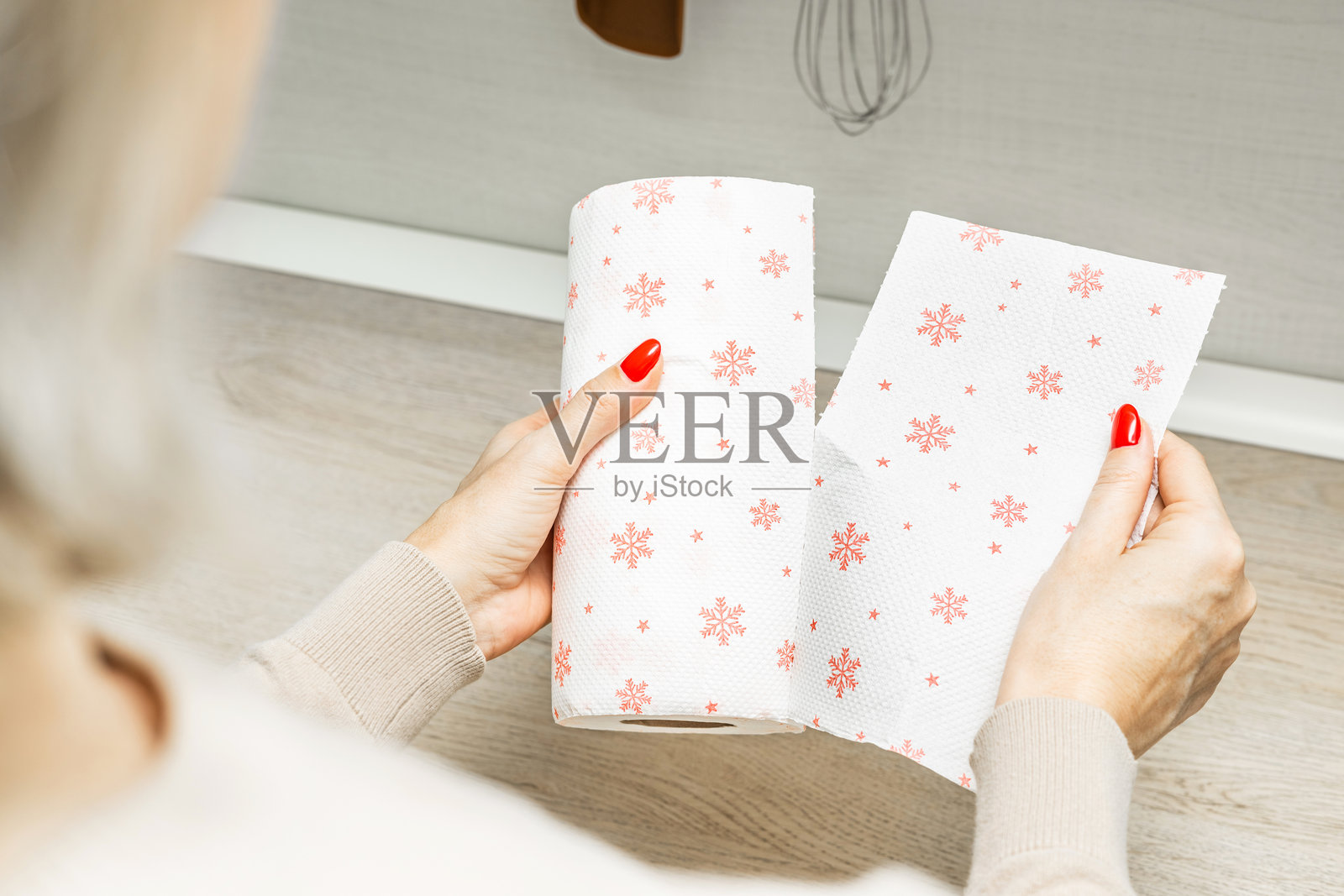 女人在厨房撕纸巾。照片摄影图片