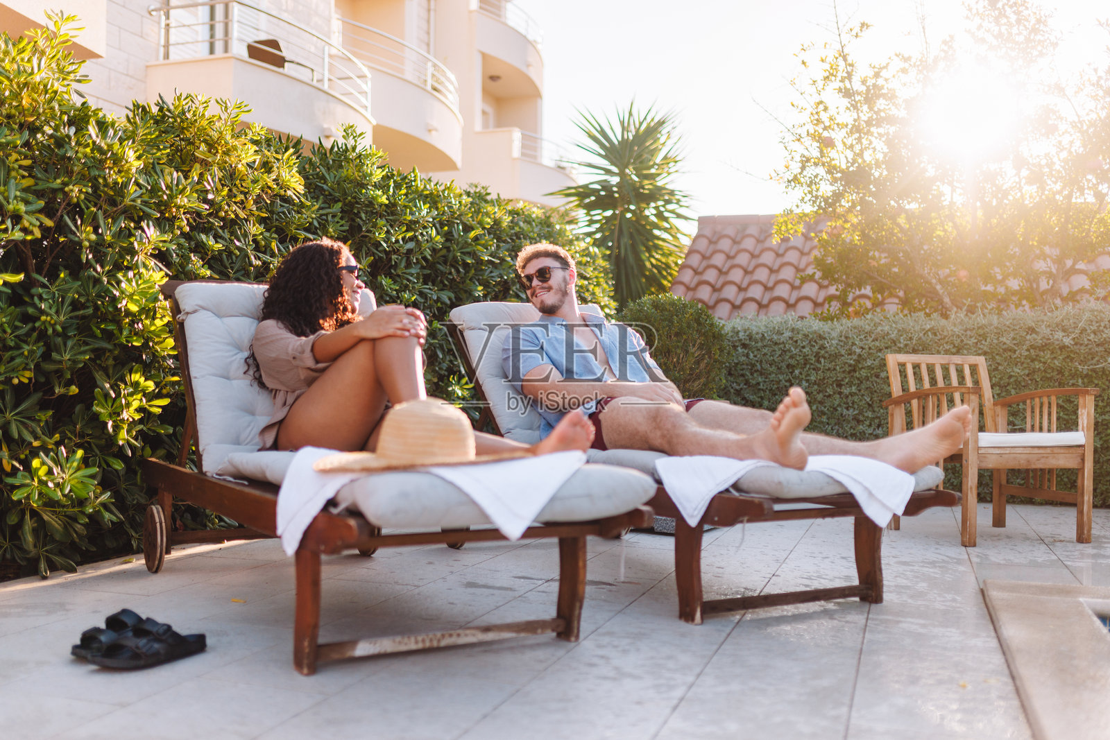 奢华度假村泳池边放松的情侣照片摄影图片