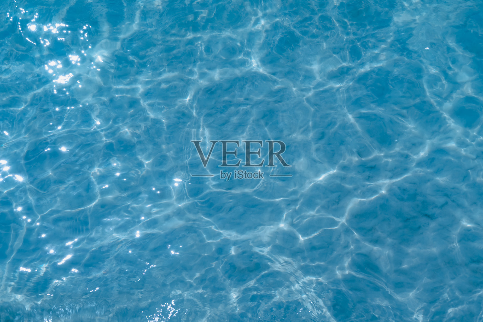 蓝色水面抽象的俯视图。屏幕中央是移动水面上的波浪特写。蓝色海洋水面与波浪的背景。照片摄影图片