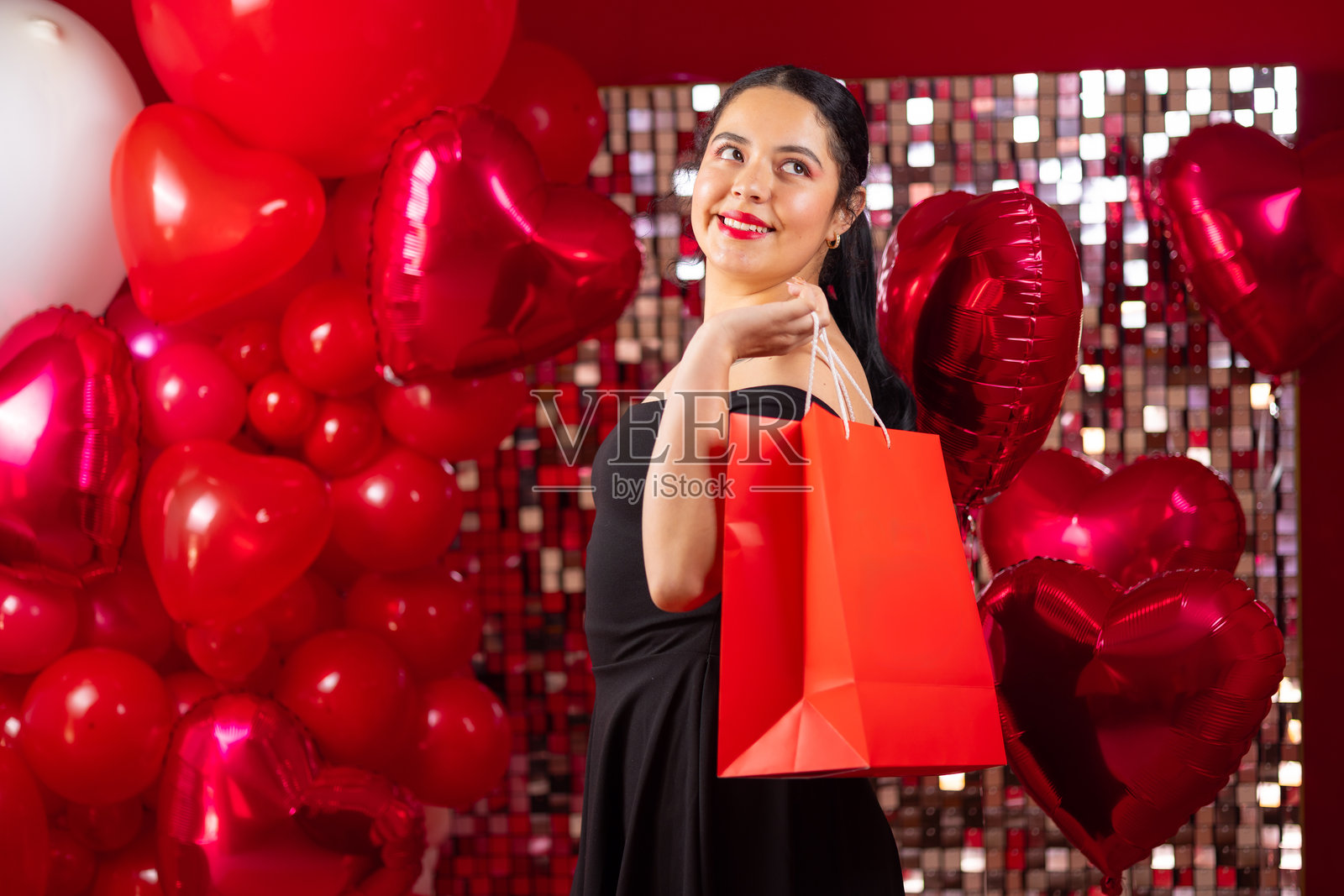 年轻女性手持庆祝用的礼品袋照片摄影图片