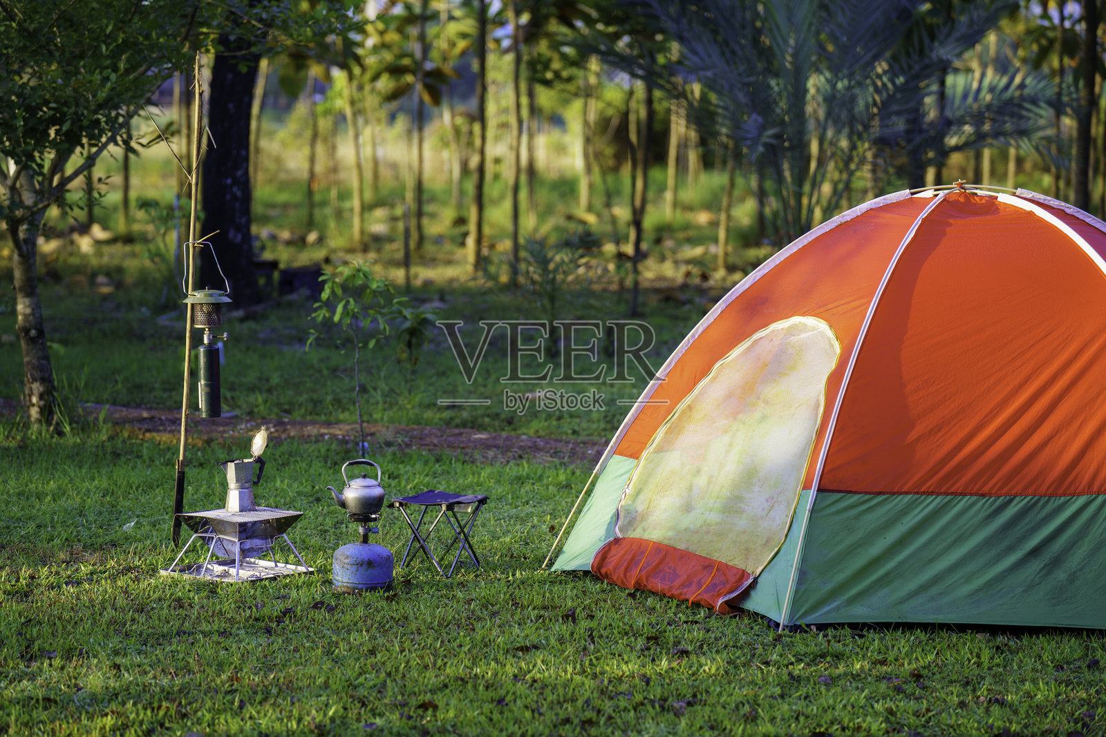 清晨日出时，森林露营区内的帐篷和户外咖啡制作设施照片摄影图片