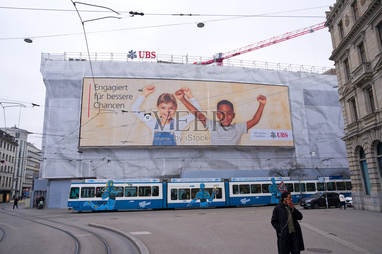 瑞士苏黎世著名的广场上，瑞士银行UBS大楼的外立面，悬挂着广告横幅，周围有脚手架，冬日下午的景象。照片摄影图片