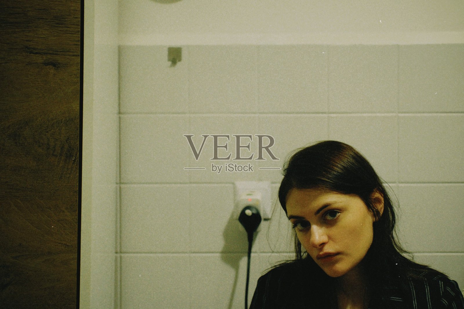 年轻女性靠在墙上照片摄影图片