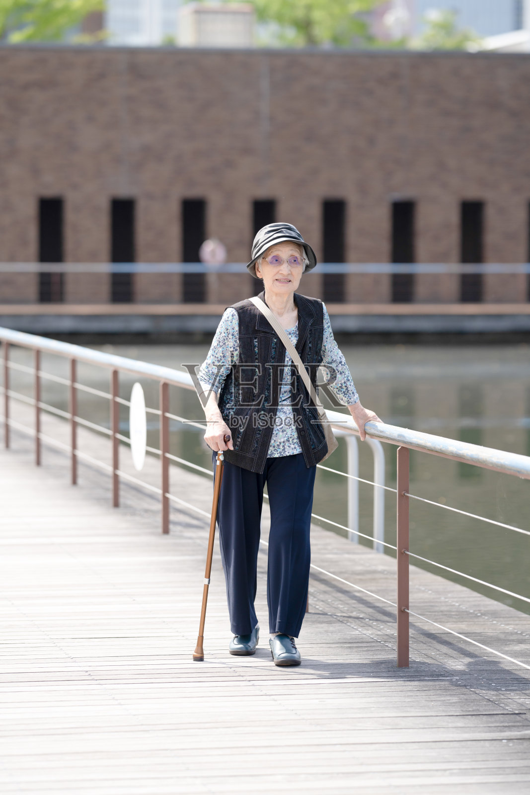 富山县一座气氛宜人的公园，公园内有运河。一位九十多岁的日本老太太在公园里散步。照片摄影图片