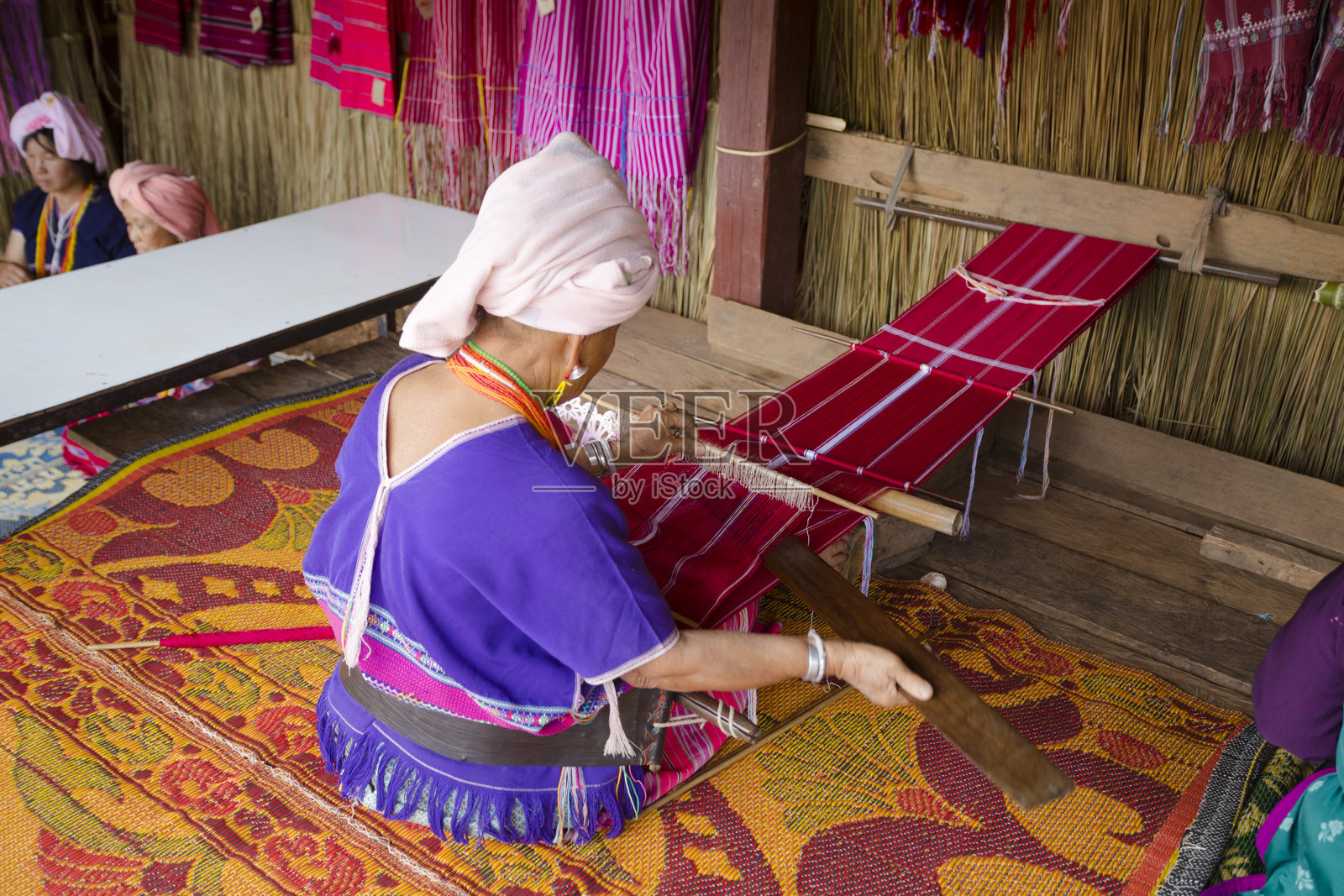泰国老年女性在织机和纺织品上工作背影照片摄影图片