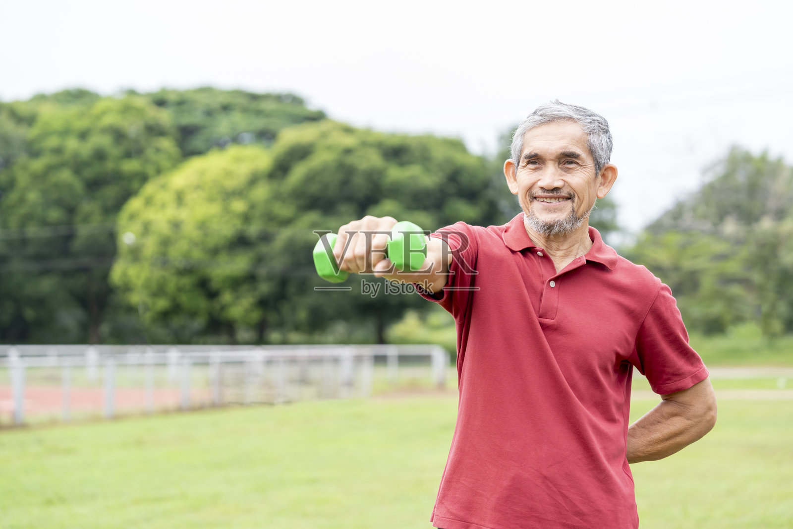 活跃的老年男性在自然公园户外用哑铃锻炼照片摄影图片
