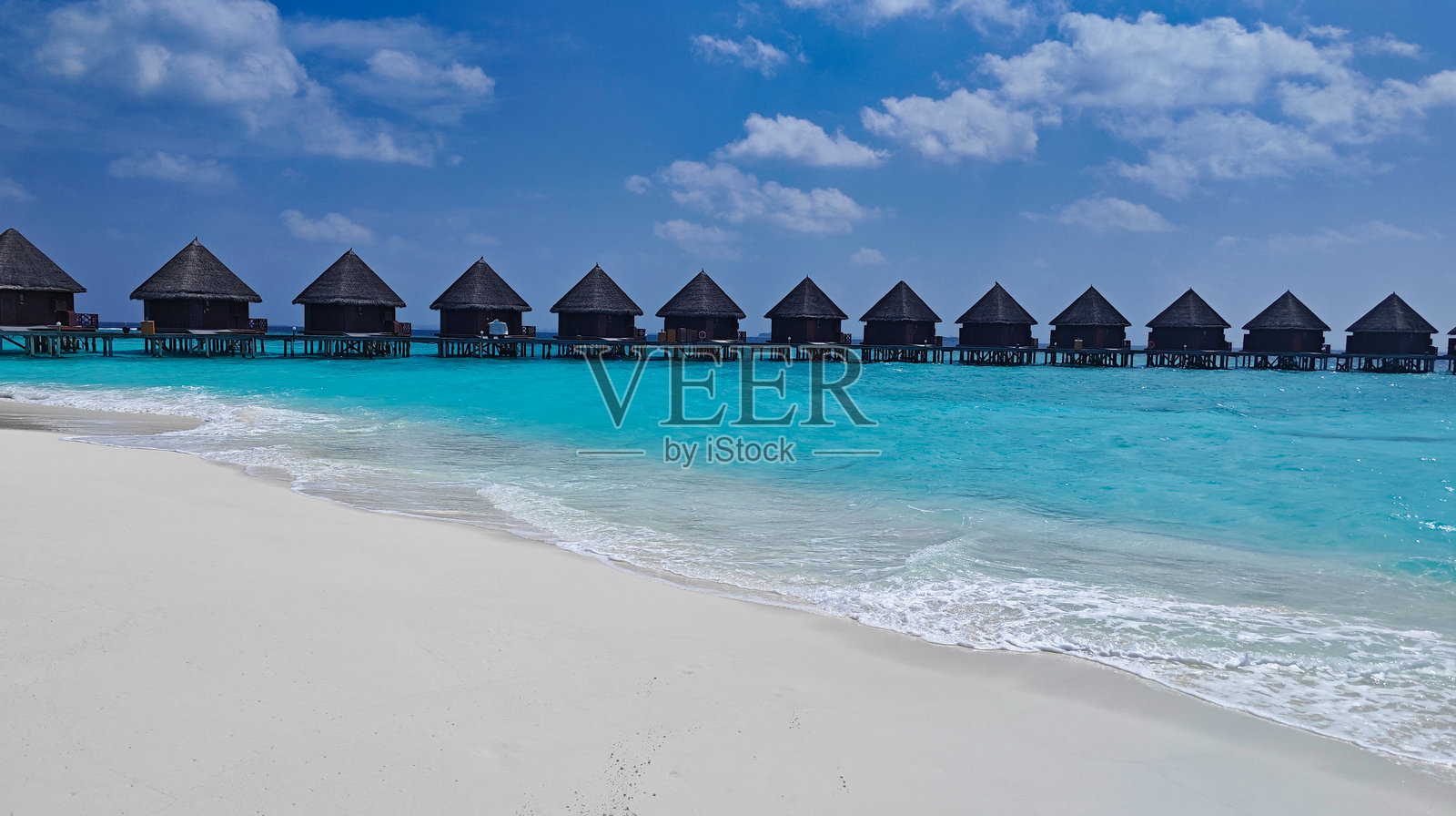 一条长长的木栈道通向马尔代夫图尔哈吉里的小木别墅。照片摄影图片