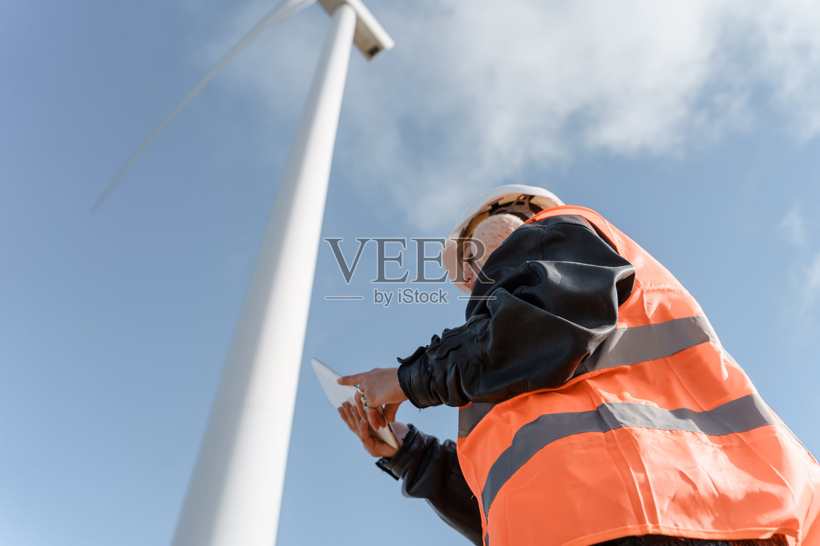 风力发电机技术员在风电场使用数字平板电脑工作照片摄影图片