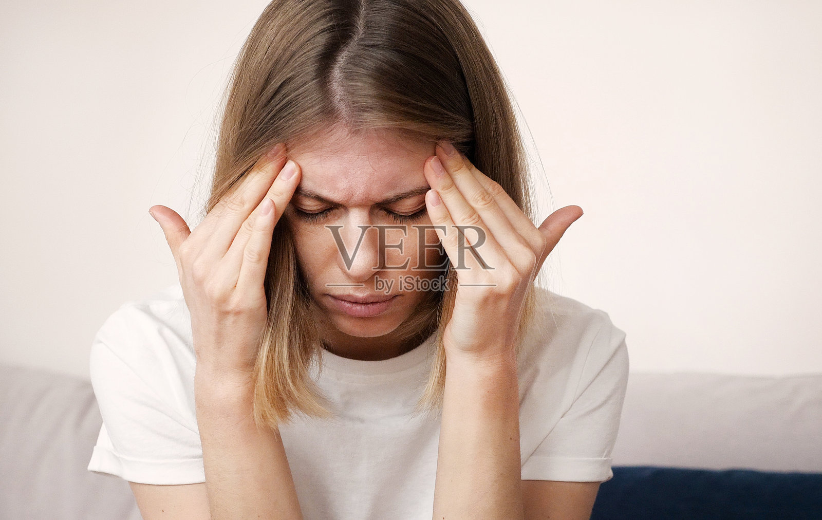 感到压力的年轻金发女性双手抱头，正在经历偏头痛。心理压力与疼痛概念视频照片摄影图片