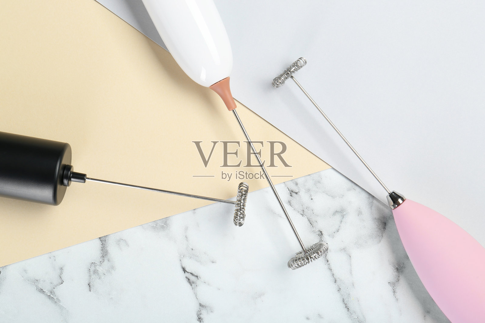 彩色背景上的牛奶泡沫器，平铺展示照片摄影图片