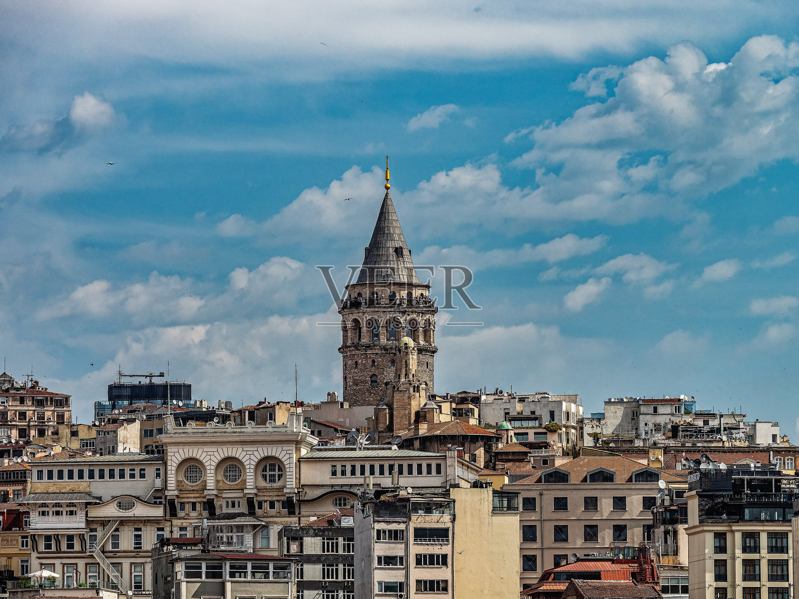 伊斯坦布尔市天际线下的历史加拉塔塔，映衬着湛蓝的天空和白云照片摄影图片