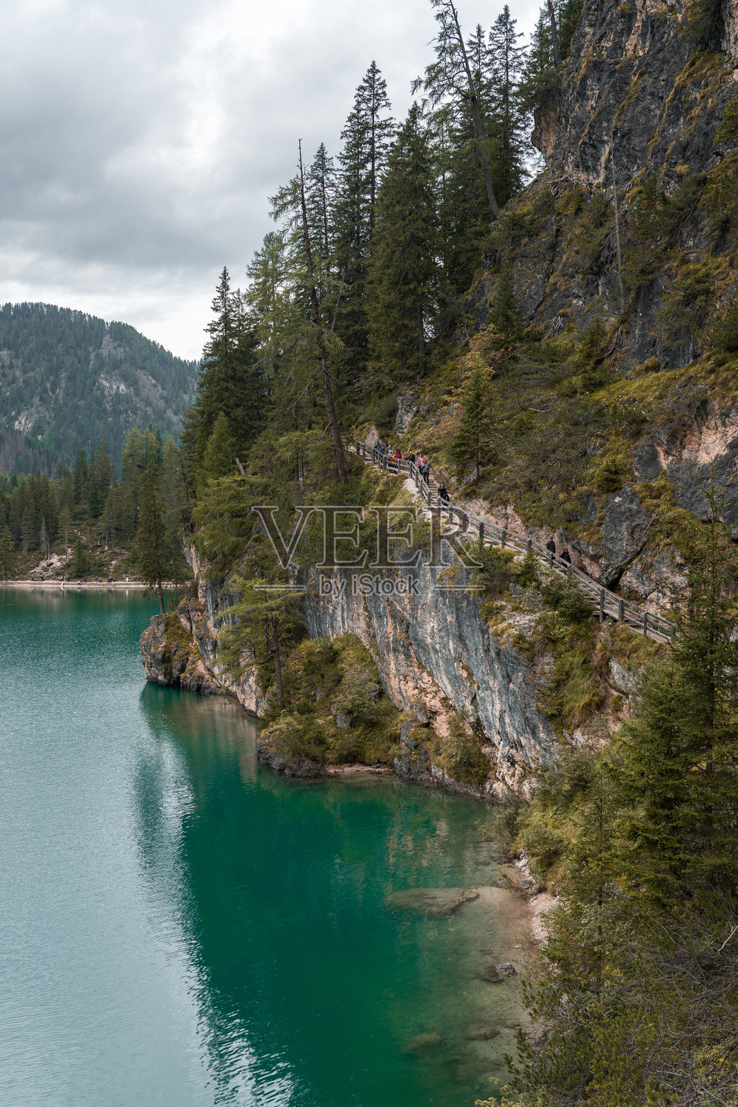 壮观的悬崖小径，远足者俯瞰碧绿色的山湖。照片摄影图片